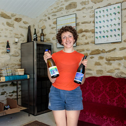 Justine WITTNER, viticultrice, posant avec deux crus issus de leurs vignes dans la Drôme provençale